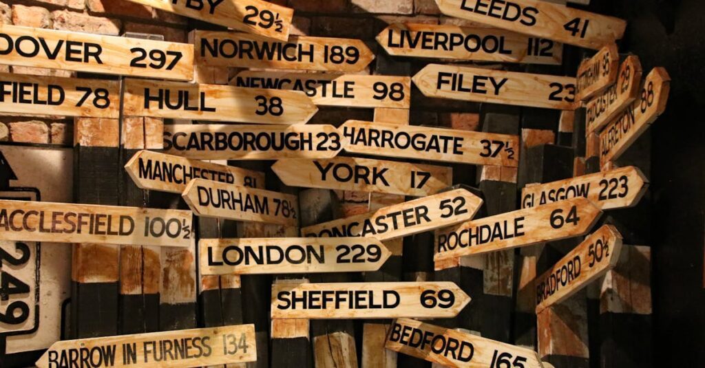 A collection of vintage wooden road signs showing distances to various UK towns and cities.