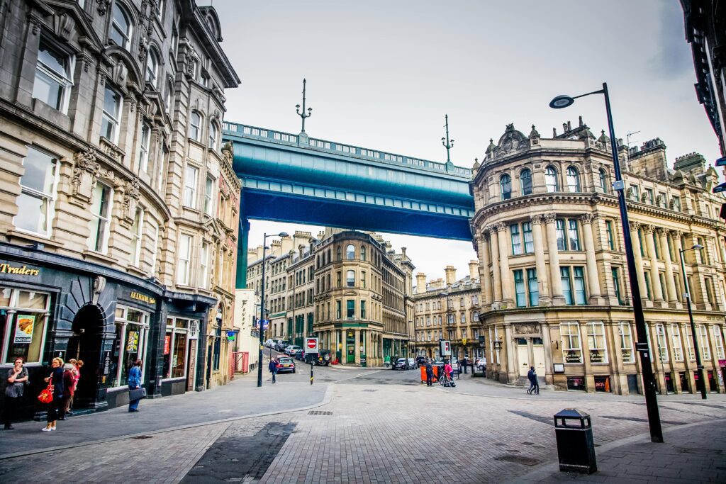 Street view of historic architecture and High Level Bridge in Newcastle, UK.