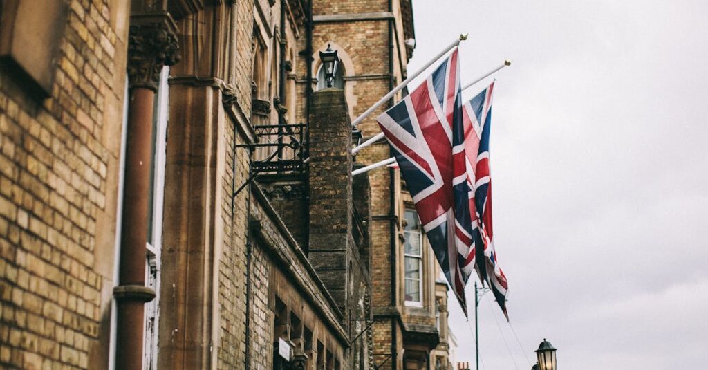 Union Jack flags adorning a historic brick building in Oxford, UK, on a cloudy day.